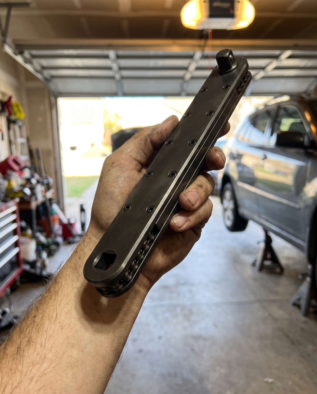 Mechanic holding the Extension Wrench 2.0 in a home garage