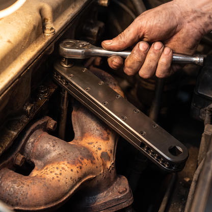 Hand turning a ratchet well above a hot exhaust manifold while the extension reaches the bolt