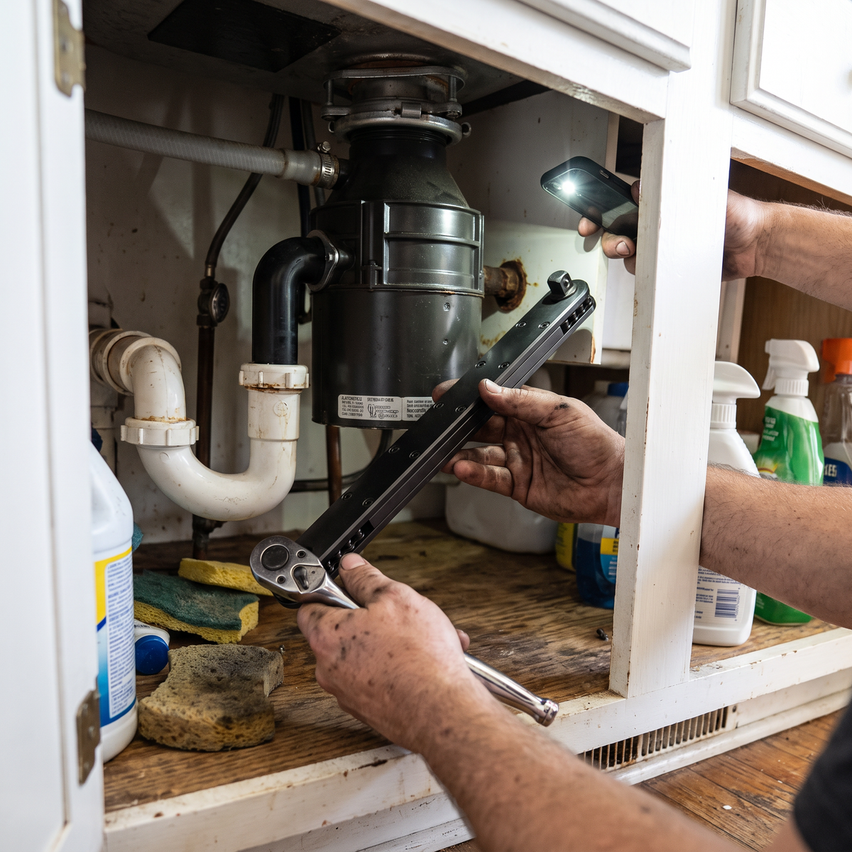 Extension Wrench 2.0 reaching a bolt behind plumbing under a kitchen sink